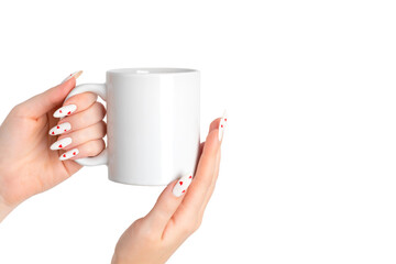 Women's hands hold a mockup of a white empty mug on a isolated background, a cup for your design...