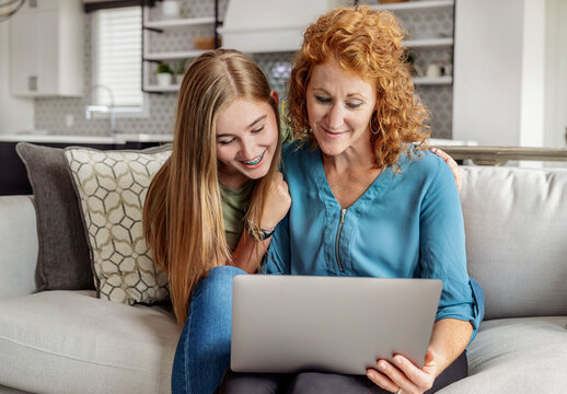 Mother and daughter looking at a laptop computer together; Edmonton, Alberta, Canda