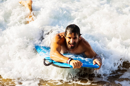 Close-up of a man riding a wave on a bodyboard into the shore at D. T. Fleming Beach; Kapalua, Maui, Hawaii, United States of America