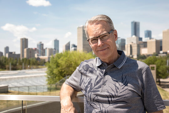 Outdoor portrait of senior man with eyeglasses, city skyline in the background; Edmonton, Alberta, Canada
