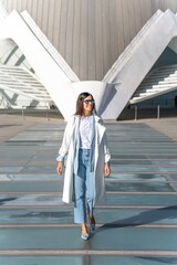 Brunette woman in white coat and jeans in Valencia © Luis