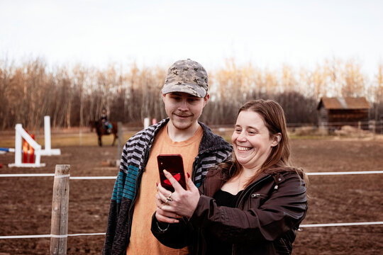 A mom with epilepsy taking a self-portrait with her son who has Aspberger Syndrome at an equine centre; Westlock, Alberta, Canada