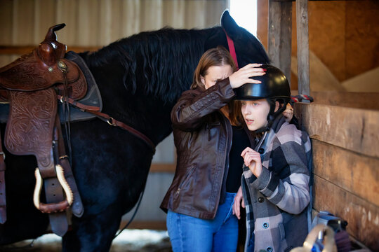 A young girl with Cerebral Palsy and her mom getting ready for a Hippotherapy session with the horse; Westlock, Alberta, Canada