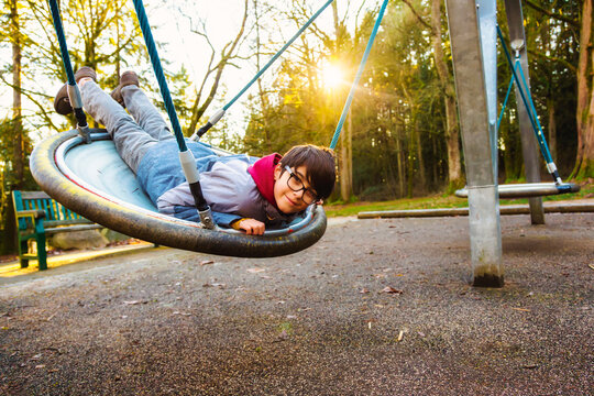 A boy plays on a saucer at a playground in autumn; Langley, British Columbia, Canada