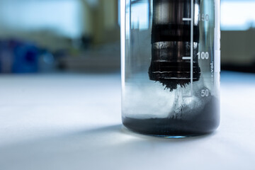 Iron nanoparticles in a lab, on a white glossy surface