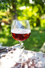 A glass of dark beer in a glass, standing on a table, outdoor recreation. Summer picnic.