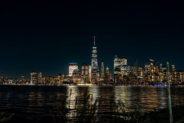 Fototapeta na wymiar New York - Manhattan at night. Skyscrapers of a large metropolis. Night city at long exposure. Towers in the big city.
