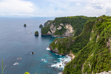 Fototapeta na wymiar Beautiful coastline view from Saren Cliff Point. Clear water and rocks with cloudy sky. Nusa Penida, Indonesia.