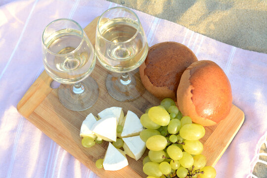 Glasses With White Wine And Snacks For Beach Picnic On Sand Outdoors, Above View