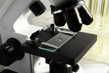 Microscope with drop of urine on glass slide in laboratory, closeup
