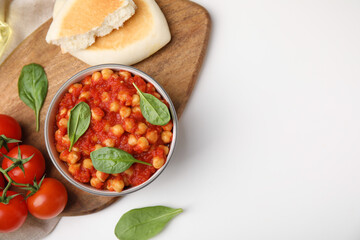 Delicious chickpea curry served on white table, flat lay. Space for text