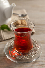 Glass of traditional Turkish tea on white wooden table, closeup