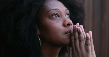 Fototapeta na wymiar Hopeful African woman praying to God seeking FAITH and HOPE