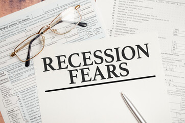 Recession fears symbol. Words on white paper with tax forms