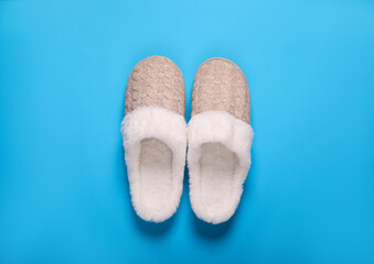 Pair of beautiful soft slippers on light blue background, top view