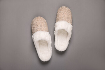 Pair of beautiful soft slippers on grey background, top view