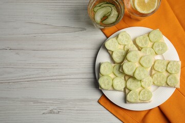 Tasty sandwiches with butter and cucumber served on white wooden table, flat lay. Space for text
