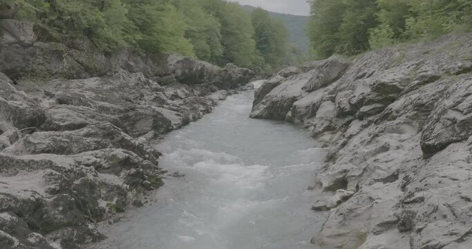 Aerial view of Mountain river and road. Flying over a mountain gorge. Slow motion 120 fps, ProRes 422, 10 bit ungraded DJI D-LOG video