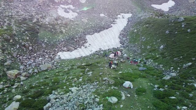 Quadrocopter shoot travelers to high green mountains in the wild nature. The beautiful view from sky with drone 
