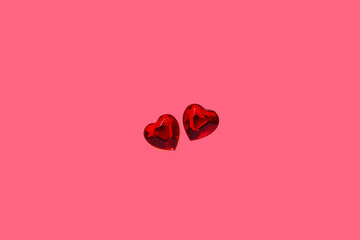 Love in valentine's day concept. Two heart shaped rubies over pink background