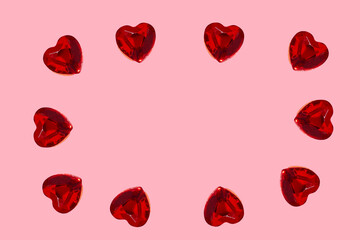 Love in valentine's day concept. Design with copy space. Heart shaped rubies over pink background forming circle around blank space for text