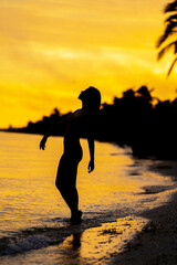 A Nude Latin Model Poses Against The Colorful Sky As The Sun Rises On The Pacific Ocean In Baja...