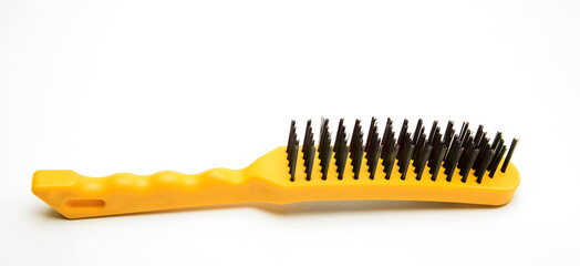 Wire brush, a tool consisting of a brush whose bristles are made of steel wire. Metal brush with plastic yellow handle. A tool for removing rust or paint. on white background