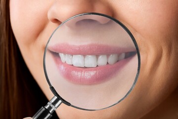 Magnifying glass and woman's white teeth