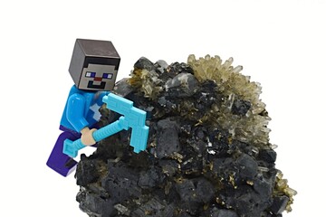 Fototapeta premium LEGO Minecraft figure of Steve with diamond pickaxe climbing on Galena, Sphalerite and Quartz mineral rock, white background