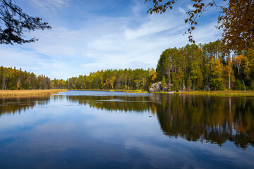 Fototapeta na wymiar Calm lake in northern Minnesota with trees and rocks on a bright autum day