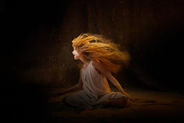 A girl in a white shirt and with long hair, looking like a ghost. A young model at a photo shoot...