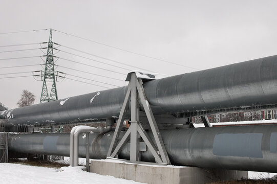 pipeline and power line in the city in winter against the gray sky.