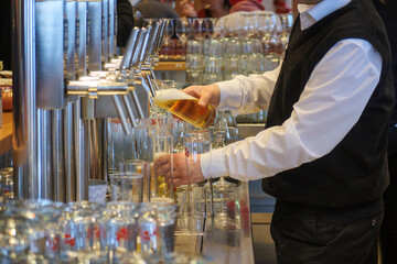 an innkeeper fills beer glasses at the bar
