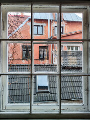 Old window. View of black roof and red wall of old building. European architecture.
