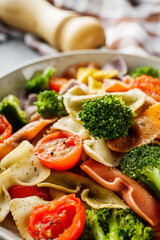 delicious colored farfalle pasta on a stone background