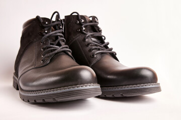 Black leather men's boots on a white background. Warm shoes for winter.