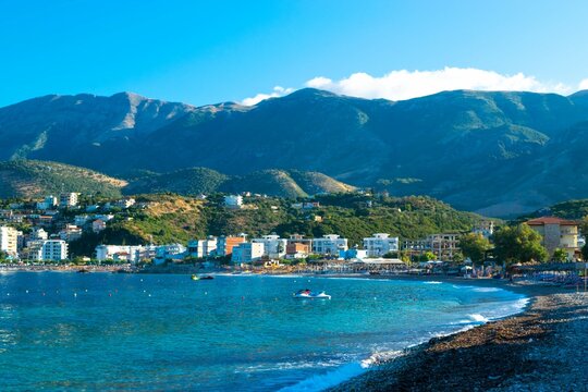Beautiful pebble beach of Himare town at foot of mountains. Adriatic sea. Albania