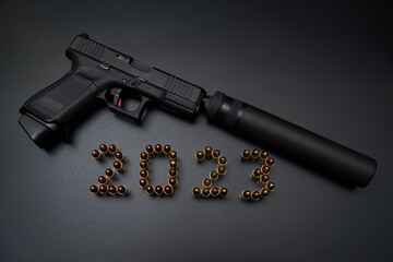 2023 with 9mm cartridges and a pistol with a silencer on a black background.