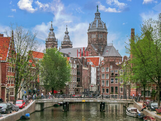 Fototapeta premium Amsterdam cityscape canal city bicycle trees Sint Nicolaas Kerk landmark Church 