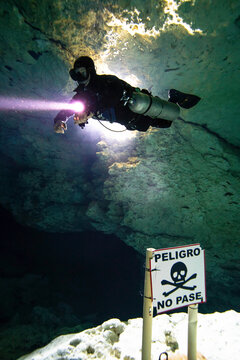 A cave diver passes a warning to keep untrained divers from entering the deeper sections of cave.