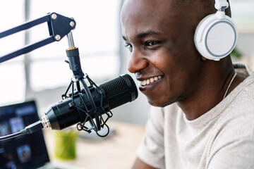 Young smiling african host streaming online live podcast from home studio