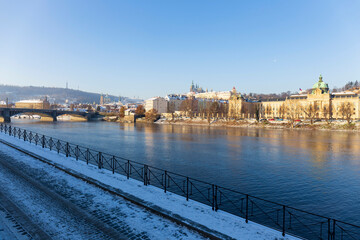 Obraz premium Snowy Prague Lesser Town with Prague Castle above River Vltava in the sunny Day , Czech republic