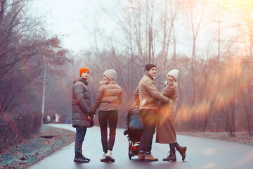 Obraz premium group friends adults park gloomy autumn, young parents walk landscape november in the city