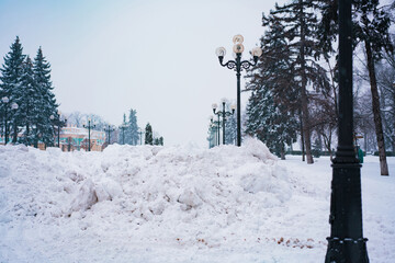 A large pile of snow was collected by the snowplow after clearing the road. Snow cleaning in winter...