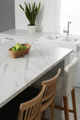 Stylish white marble table in kitchen. Interior design