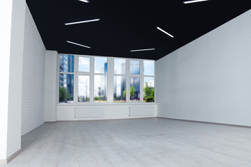 Fototapeta premium Empty office room with black ceiling and clean windows. Interior design