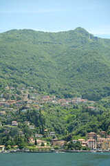 Fototapeta na wymiar Como Lake landscape. Cernobbio village, trees, water and mountains. Italy, Europe.