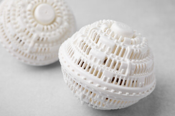 Dryer balls for washing machine on light grey table, closeup. Laundry detergent substitute