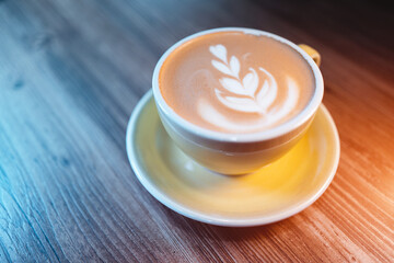 fresh tasty cappuccino or latte coffee with milky foam on wooden table in cafe