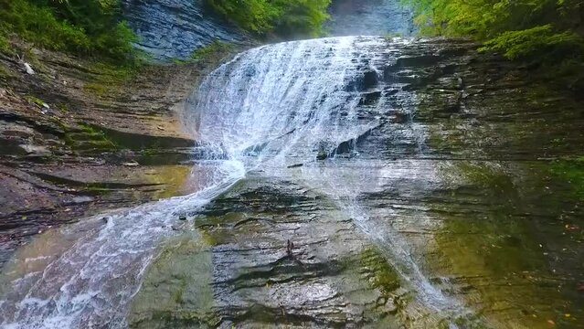 Aerial backwards over New York Buttermilk Falls State Park waterfalls